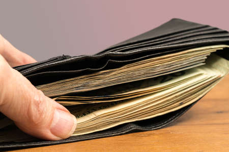 Stack of US twenty dollar bills stashed in wallet to illustrate cash or shadow economyの写真素材