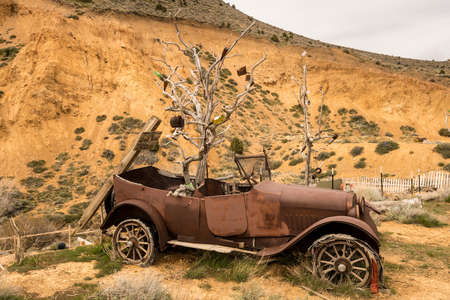 Remains of old car by quarry at entrance to the old town of Virginia City in Nevada, a center for gold and silver mining in the pastの写真素材