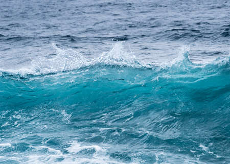Cresting ocean waves frozen with high shutter speed to show the individual droplets of water in the surfの写真素材