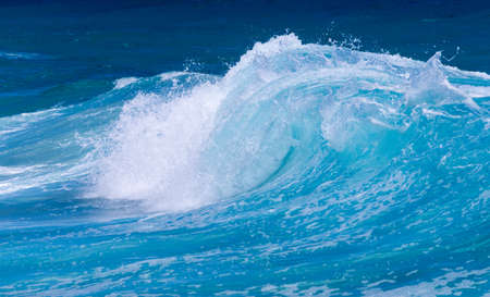 Cresting ocean waves taken with high shutter speed to show droplets of water in the surf