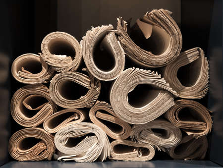 Rolls of old yellowed and worn books and papers on bookshelfの写真素材