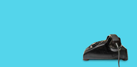 Side view of old and antique rotary telephone on blue background