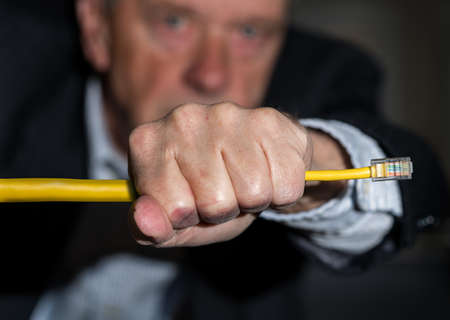 Senior caucasian businessman choking or slowing streaming data in illustration of net neutrality regulationsの写真素材