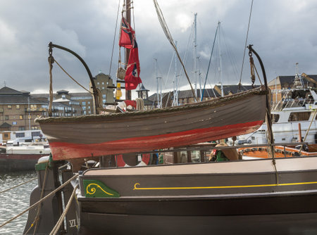 LONDON, UK - JANUARY 30, 2016: Wooden rowing boat in rigging of old wooden sailing ship in Limehouse Basin Marina in Docklands, London, Englandのeditorial素材