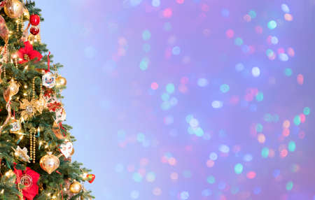 Ornately decorated christmas tree with defocused lights on blue background for copy space for...