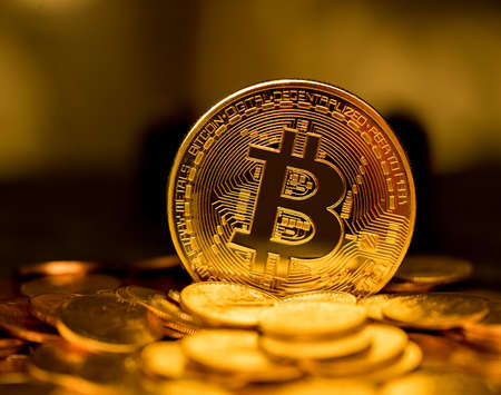 Stack of bit coins or bitcoin on gold background to illustrate blockchain and cyber currency