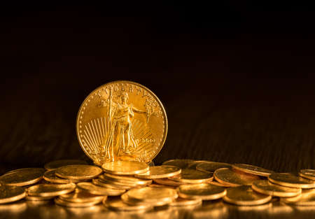 Gold Eagle one ounce coin against a golden background of other coins with focus on the Liberty symbolの写真素材