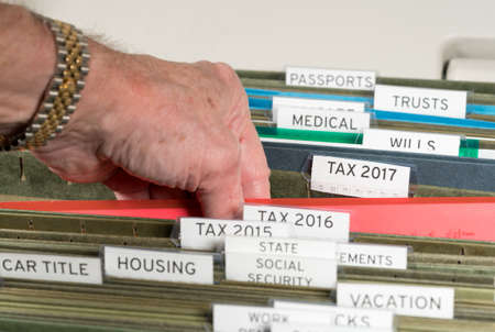 Close up of a well organized home filing system with tabs for each subject and focus on tax return papers for 2017の写真素材