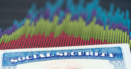 Social Security card in the USA laid on top of charts and graphs of budget in retirement