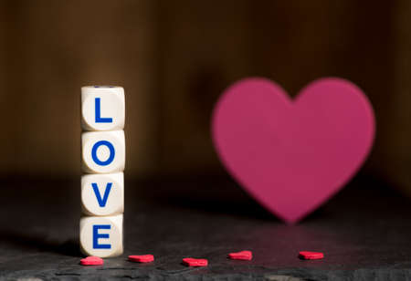 Love spelled in wooden blocks with heart shaped cutouts for Valentines day with copy spaceの写真素材