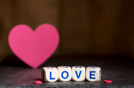 Love spelled in wooden blocks with heart shaped cutouts for Valentines day with copy spaceの写真素材