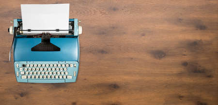 Modern electric typewriter on wooden desk background with copy space for hero headerの写真素材