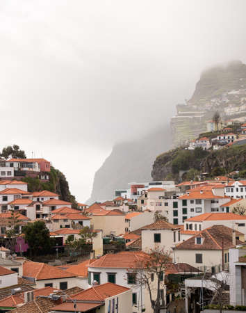Cliffs by the bay and beach at Camara de Lobos on island of Madieraの写真素材