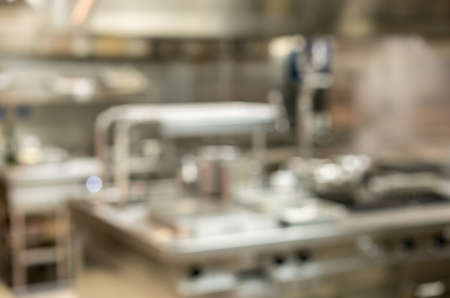 Defocused food being cooked in commercial stainless steel kitchen in restaurantの写真素材