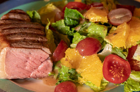 Thick New York strip beef steak cooked in sous vide and grilled on plate with lettuce saladの写真素材