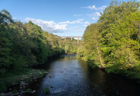 Spring trees frame the old Pontcysyllte Aqueduct near Chirk carrying Llangollen Canal across river Deeの写真素材