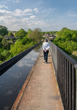 Tourist on the top of old Pontcysyllte Aqueduct near Chirk carrying Llangollen Canal across river Deeの写真素材