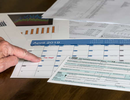 Senior hand holding Form 1040 Simplified for 2018  which allows for filing on April 15, tax day, on...