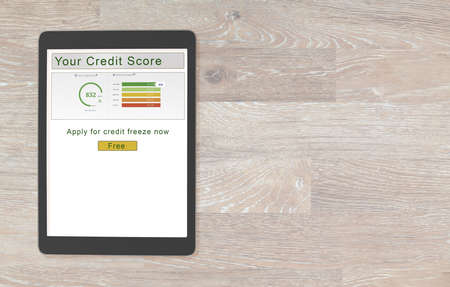 Computer tablet or smartphone with  credit score report and button to freeze the record for new law allowing free credit freezes with agencies