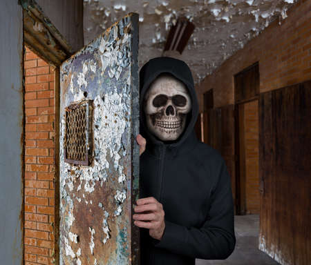 Halloween theme of man with skull welcoming visitors to haunted prison cell