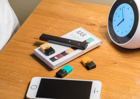 MORGANTOWN, WV - 25 AUGUST 2018: Juul e-cigarette or nicotine vapor dispenser box on bedside table...