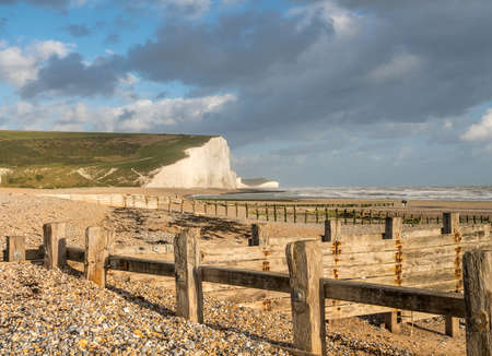 Moss covered wooden groyne frames the chalk cliffs of the Seven Sisters near Eastbourneの写真素材