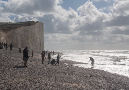 EASTBOURNE, UK - 21 SEPTEMBER 2018: Tourists on the beach on stormy day at Birling Gap near Eastbourneのeditorial素材