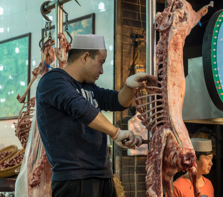 XIAN, CHINA - 17 OCTOBER 2018: Street food vendors in the Muslim quarter of Xian carving a lambのeditorial素材