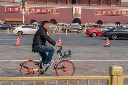 BEIJING, CHINA - 19 OCTOBER 2018: Cyclist on Mobike bike by Forbidden City in Tiananmen Square in Beijingのeditorial素材