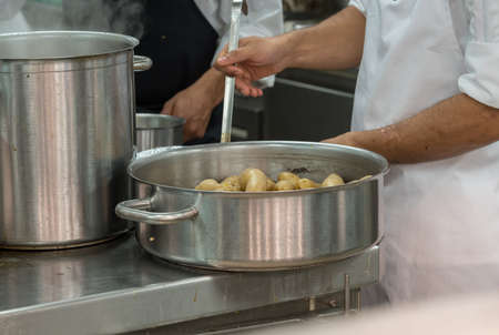 Chef preparing food  in commercial stainless steel kitchen in restaurantの写真素材