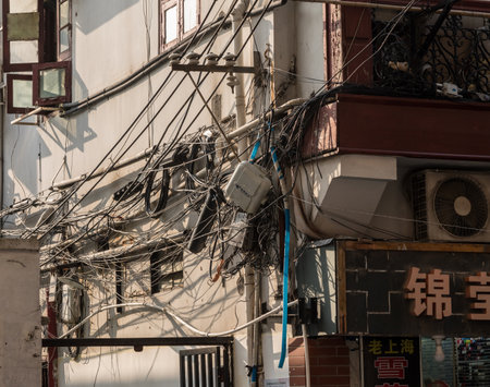 SHANGHAI - CHINA - 26 OCTOBER 2018: Tangle of electric and telephone wires on side of buildingのeditorial素材