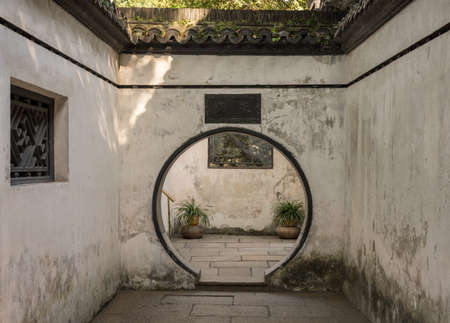 Round doorway into small courtyard in Yu or Yuyuan Garden in  the old city of Shanghaiの写真素材