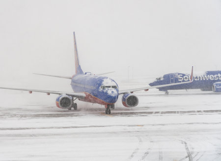 DENVER, COLORADO: JANUARY 24, 2019: Southwest plane on runway as second one passes behind in snow stormのeditorial素材
