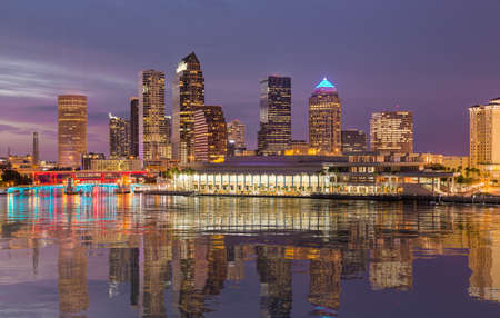 Florida skyline at Tampa with the Convention Center on the riverbank. Lights are reflected in a smooth artificial water  surfaceの写真素材