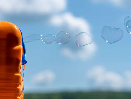 Childrens toy soap bubble blower creating bubbles on sunny summer dayの写真素材
