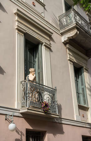 Statue on a wrought iron balcony in ancient district or neighborhood of Plaka in Athens by the Acropolisの写真素材