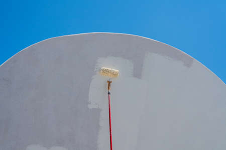 White paint being applied by roller to traditional house in Santoriniの写真素材