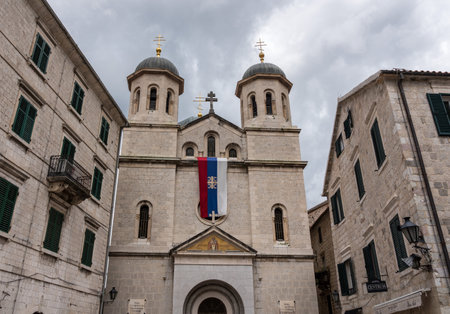 KOTOR, MONTENEGOR - 21 MAY 2019: Serbian flag flies on St Nicholas church in old town Kotor in Montenegroのeditorial素材