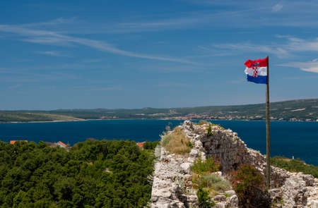 Croatian flag flies above ruins of old Venetian fort above the coastal town of Novigrad in Croatia