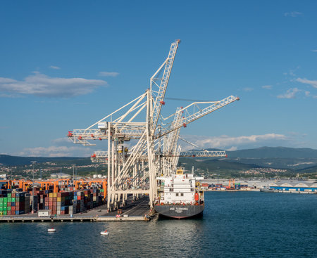Koper, Slovenia - 24 May 2019: Cranes load containers onto ship in the container port of Koper in Sloveniaのeditorial素材