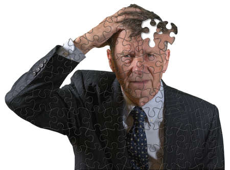 Front view and face of senior caucasian man afraid of dementia and Alzheimers disease using jigsaw...