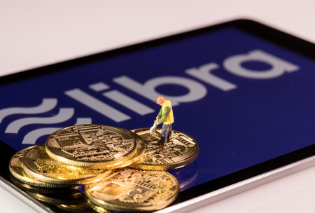 Morgantown, WV - 14 July 2019: Golden cybercurrency coins on top of tablet computer as concept for Facebook Libra blockchain currencyのeditorial素材