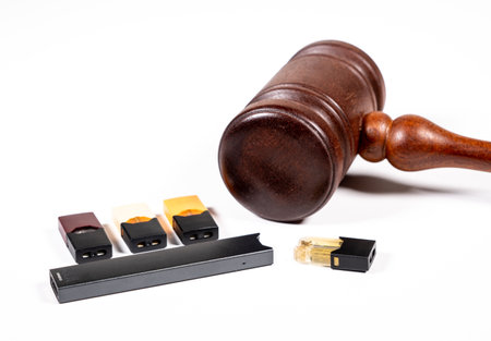 MORGANTOWN, WV - 29 AUGUST 2019: Juul e-cigarette or nicotine vapor dispenser box with Judges gavel for lawsuitのeditorial素材