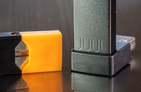 Morgantown, WV - 10 September 2019: Juul e-cigarette and nicotine vaping container on metal tableのeditorial素材