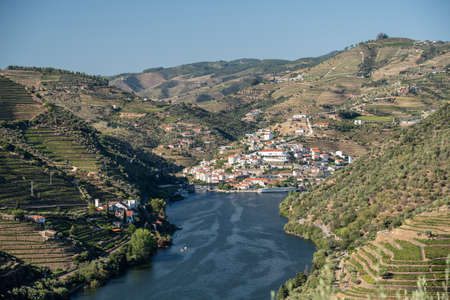 Village of Pinhao on bend in river among the hillsides of the Douro valley in Portugalの写真素材