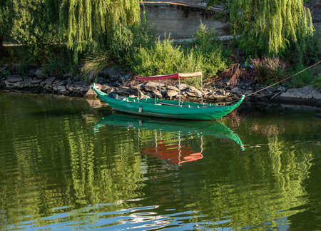 Fishing or rowing boat anchored in the calm waters on the bank of the River Douro in Portugalの写真素材