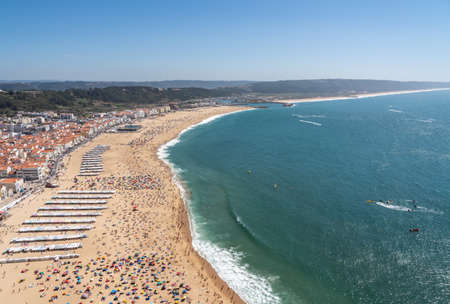Crowded beach of Nazare from above with tourists relaxing on the sandの写真素材