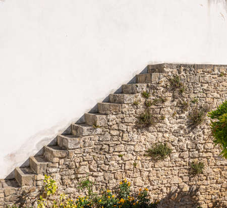 Unusual stone stairs leading nowhere in the old medieval walled city of Obidos in Portugalの写真素材