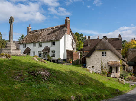Whitewashed homes surrounding the village green in the pretty Devon village of Lustleighの写真素材