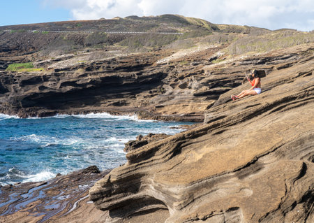 Waikiki, HI - 25 January 2020: Woman taking a selfie from the eroded rocks by Halona Blowhole on the east coast of Oahuのeditorial素材
